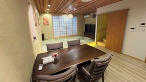 A traditional Japanese-style room with tatami flooring, a low wooden ceiling, and a sliding door leading to another room. - SUN WARM HOUSE (Osaka)