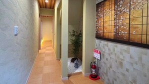 A hallway with wooden ceiling and walls, a fire extinguisher, a bench, and a small plant. - SUN WARM HOUSE (Osaka)