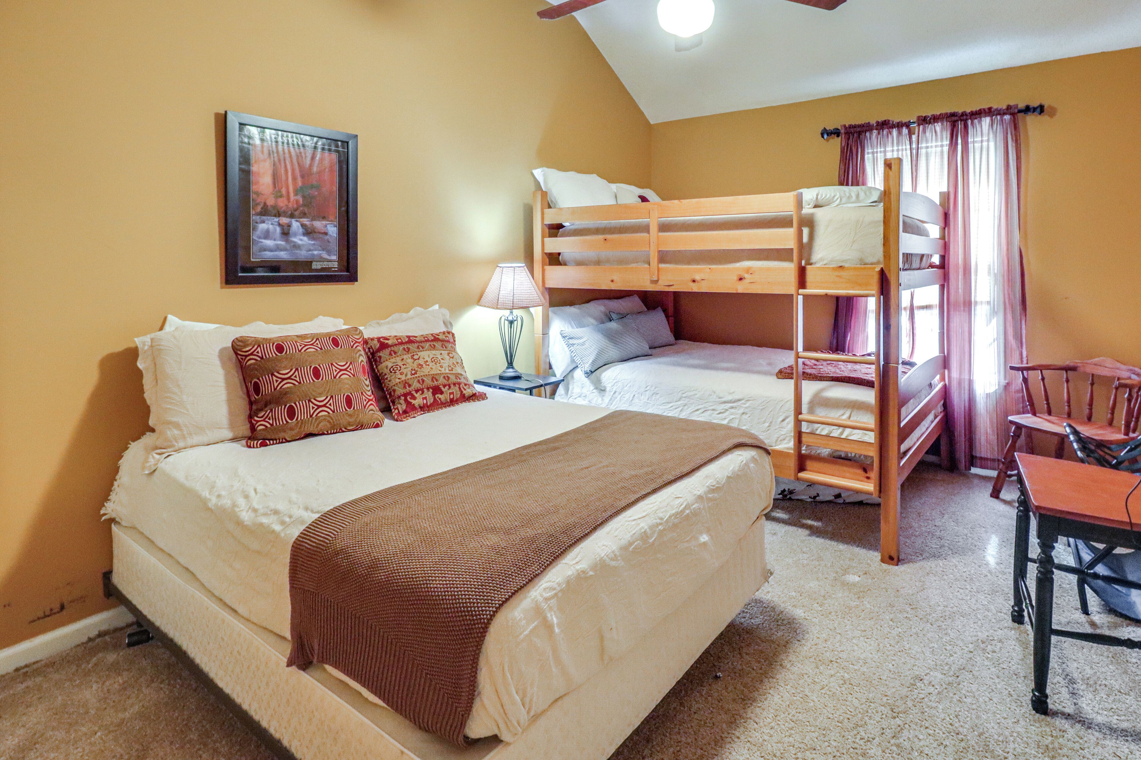 A bedroom with two beds, a desk, and a chair.