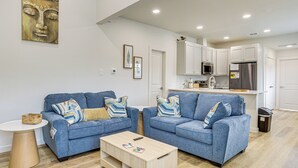 A modern living room with two blue sofas, a wooden coffee table, and a small side table. - Great for Travel Nurses: 2BR East Dallas Townhome! (Dallas)
