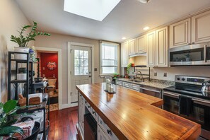 Una cocina moderna con encimeras de madera, electrodomésticos de acero inoxidable y un tragaluz.
