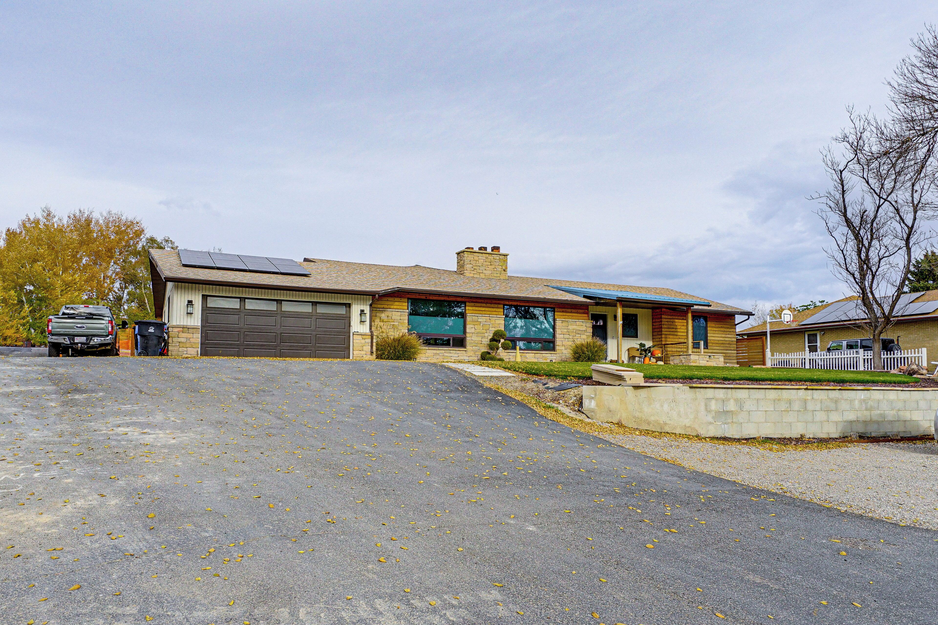 A two-story house with a garage, solar panels, and a driveway.
