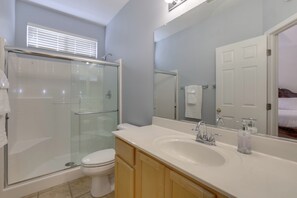 A bathroom with a glass-enclosed shower, a white sink, and wooden cabinets. - Hike, Golf & Relax: Desert Retreat in Cave Creek (Cave Creek)