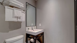Un baño con inodoro, lavabo y perchero para toallas.