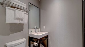 A bathroom with a toilet, sink, and towel rack. - Dream Suites - Deluxe Family  Suite (MISSISSAUGA)