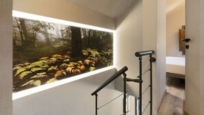 Um interior moderno com uma grande janela que mostra uma paisagem florestal.
