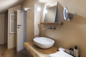 Ein modernes Badezimmer mit Waschbecken, Spiegel und Ablagefläche für Pflegeprodukte.