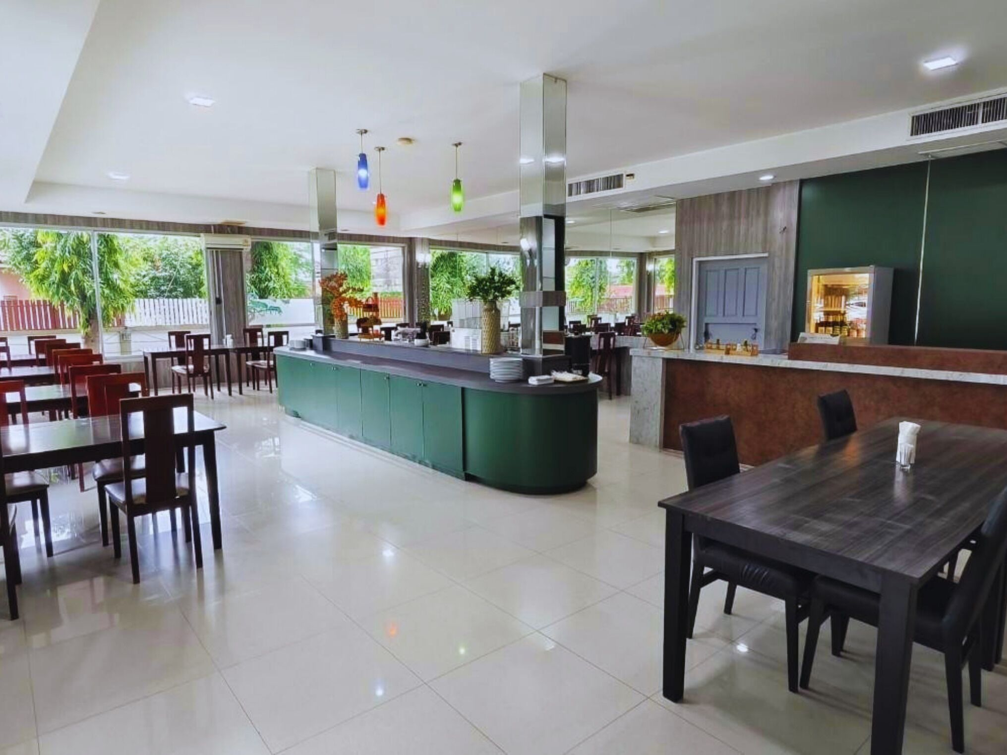 Un restaurante moderno con una isla central, mesas y sillas para comer.
