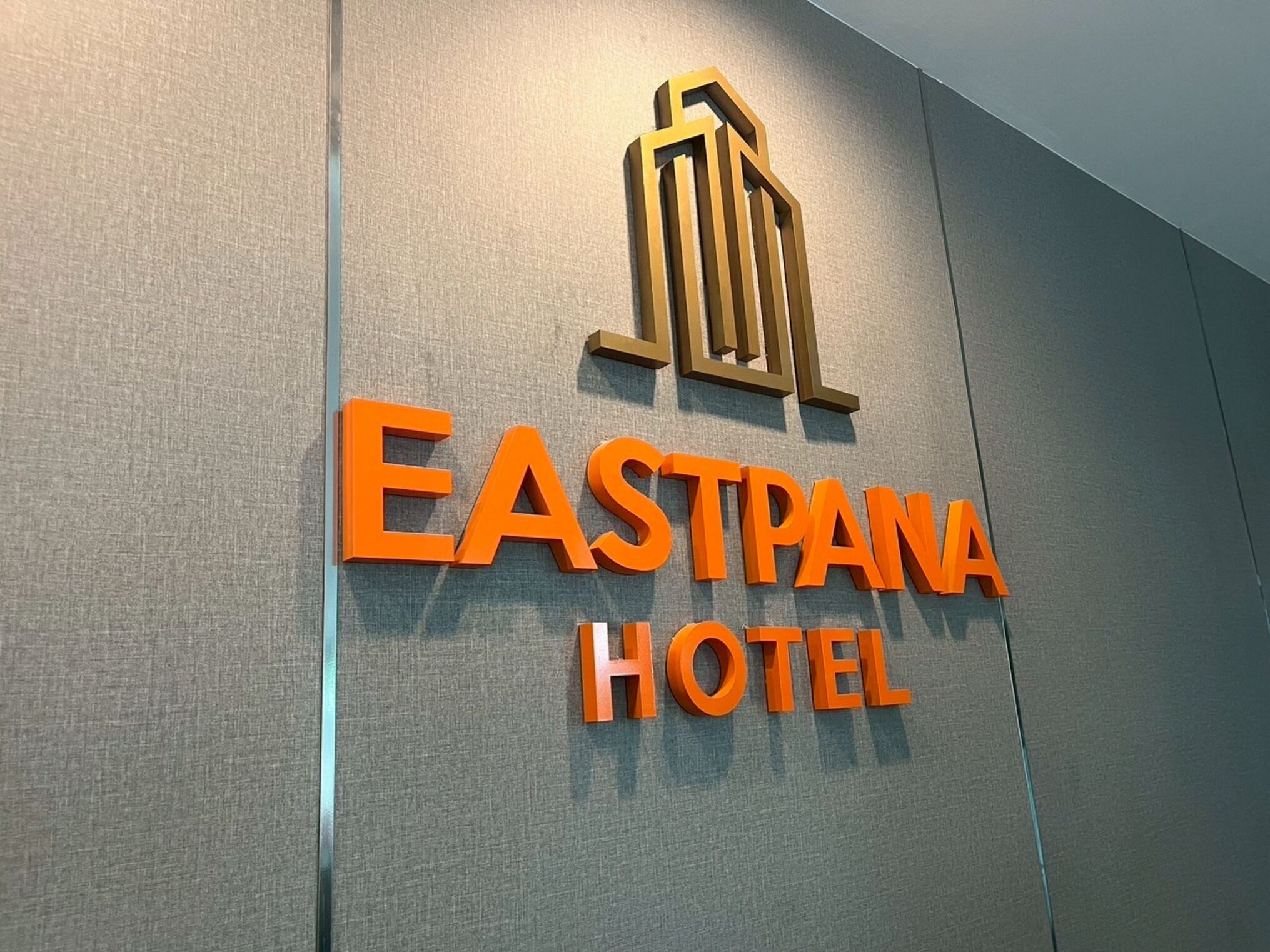 A sign for Eastpana Hotel with a modern design and a logo above the name.