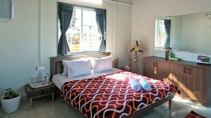 A bedroom with a bed, bedside table, lamp, and a large mirror. - Cosmicstays Birdsong Lakeview Cottage  (Velhe)