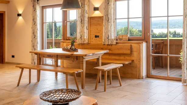 Een houten eethoek met een tafel, banken en een mand.