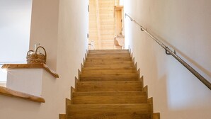 Una escalera de madera con barandilla que sube a un piso superior.