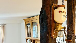 Une cuisine rustique avec des poutres en bois, une machine à café et des ustensiles de cuisine d’époque.