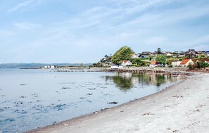 A coastal area with a sandy beach, calm water, and houses with red roofs. - Cozy home in Ebeltoft with sauna (Ebeltoft)