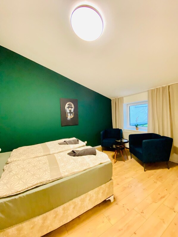 A hotel room with a bed, two chairs, a small table, and a window with curtains. - Spacious 8BR Apt with Terrace 16P (Vienna)