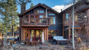 A two-story log cabin with a balcony, stone chimney, and a deck with outdoor furniture. - Truckee Escape w/ Hot Tub, Chef’s Kitchen & Minutes to Skiing, Dining & Trails (Truckee)