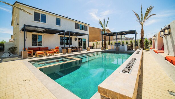 Ein modernes Haus mit Schwimmbad, Sitzgelegenheiten im Freien und einer überdachten Terrasse.
