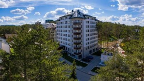 A multi-story hotel with a central courtyard, surrounded by trees. - Zlatibor Deluxe Suites with Spa Fitness (Zlatibor)