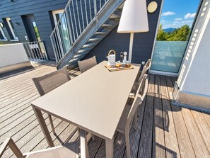 A deck with a table and chairs, a lamp, and a tray with items. - Modern vacation apartment with exceptional views and its own infrared cabin (Winterberg)