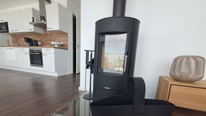 Uma cozinha moderna com armários brancos, fogão preto e uma mesa de jantar de vidro.