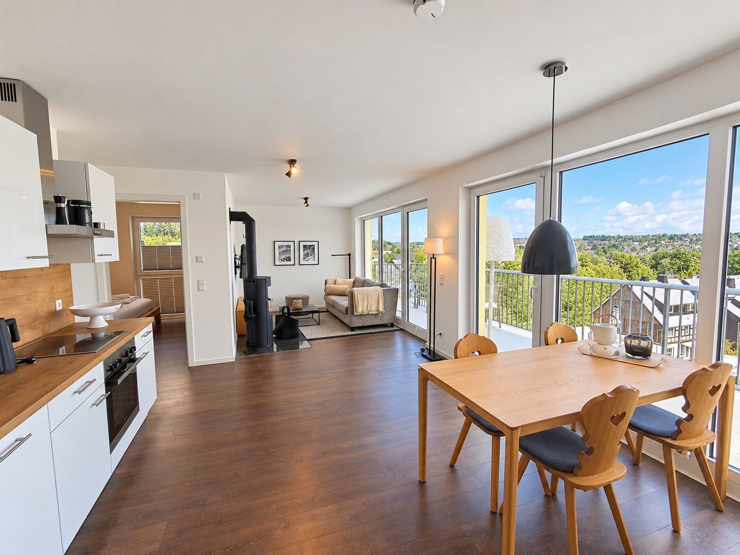 Une cuisine moderne avec des meubles en bois et un coin repas comprenant une table et des chaises.