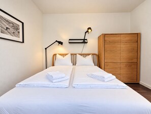A double bed with two pillows, a bedside lamp, a wooden wardrobe, and a framed picture on the wall. - Modern lodge with exceptional countryside views and private sauna - (Winterberg)