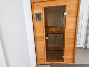 Une porte en bois dotée d’un thermostat intégré et sur laquelle est accrochée une serviette à l’intérieur.