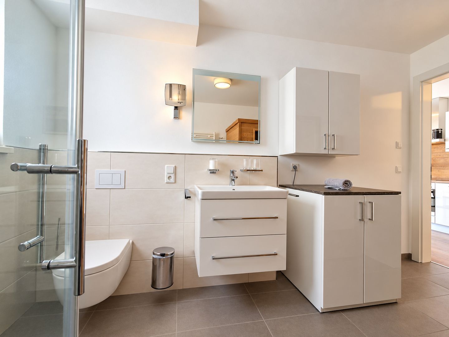 Un baño moderno con inodoro, lavamanos y armarios.