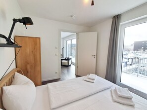 A hotel room with a bed, a desk, a chair, a lamp, and a view of the outside. - Modern lodge with exceptional countryside views and private sauna - (Winterberg)