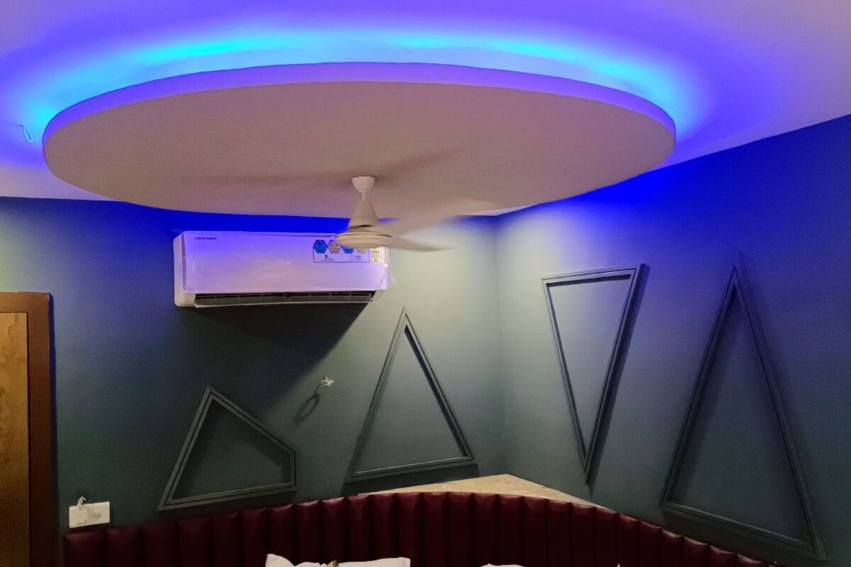 A room with a ceiling fan, air conditioning unit, and triangular wall decorations.