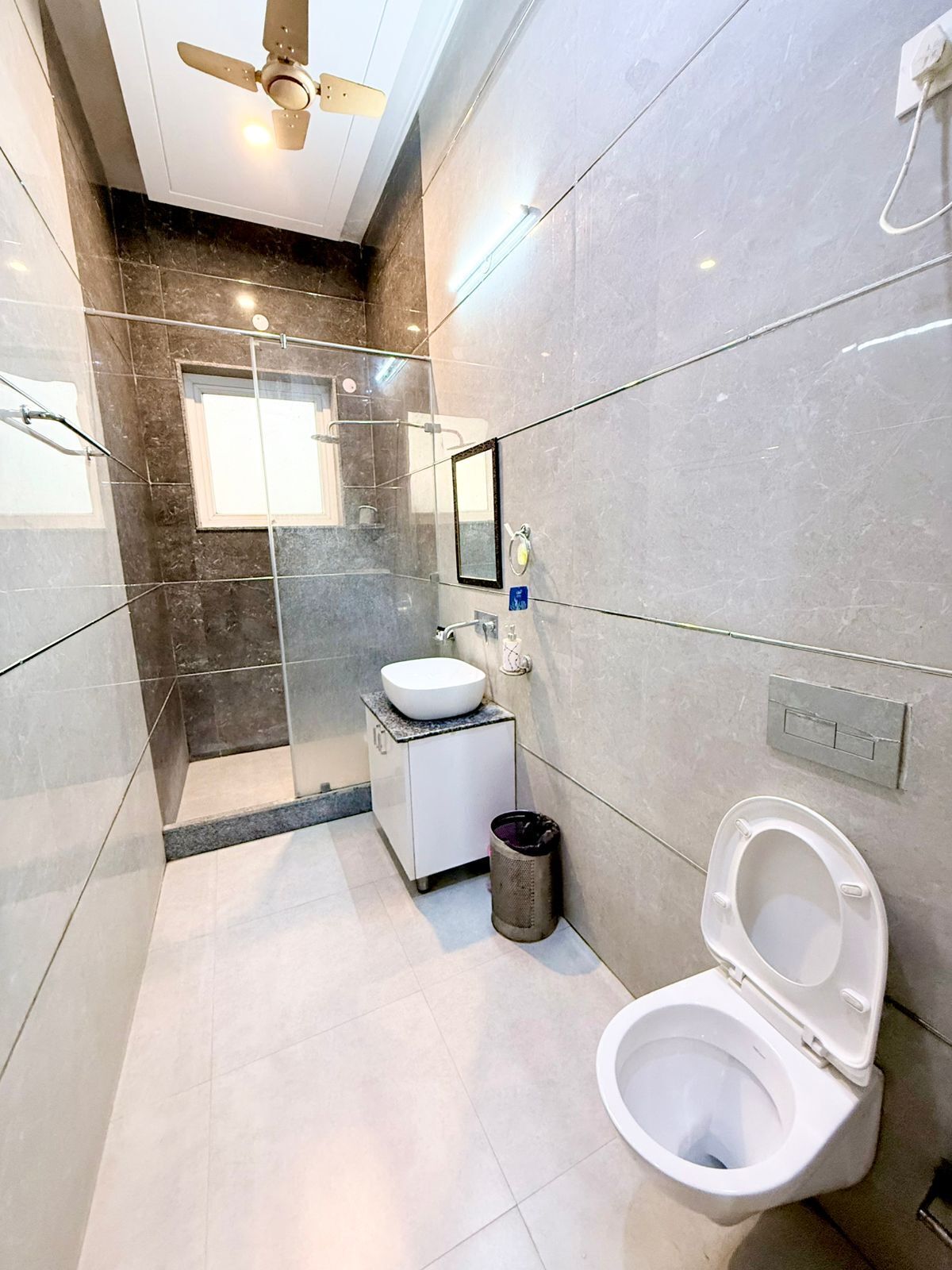 A modern bathroom with a toilet, sink, and shower area.