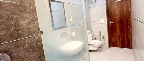 A modern bathroom with a glass shower enclosure, a sink, and a toilet.