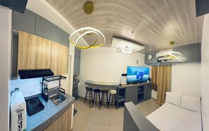 A modern kitchen with a built-in oven, a sink, and a bar area with stools.