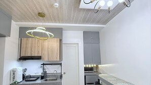 Une cuisine moderne avec des meubles en bois, un four encastré, un évier et un coin bar avec des tabourets.