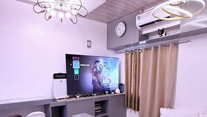 Une chambre moderne équipée d’un lit, d’un bureau, d’une télévision et d’un ventilateur de plafond.