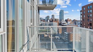 Un edificio de gran altura con un balcón de vidrio que ofrece vistas a un paisaje urbano.