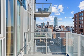 Ein Hochhaus mit einem Glasbalkon und Blick auf eine Stadtlandschaft.