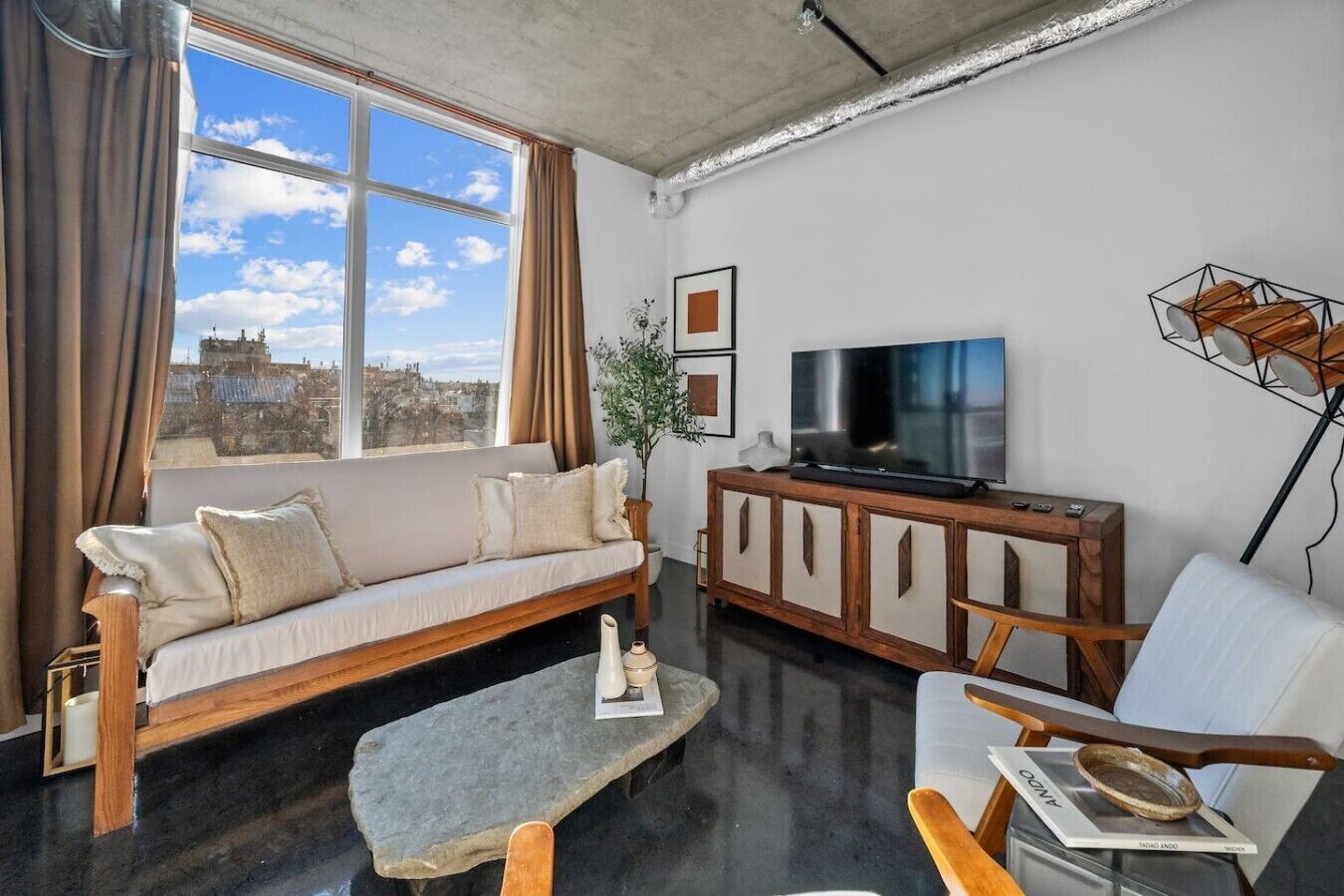 A modern living room with a sofa, a coffee table, a TV, and a cabinet.