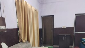 Una habitación pequeña con un sofá, una mesa de madera, un armario y una puerta.