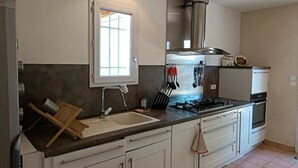 Una cocina moderna con una isla grande, electrodomésticos de acero inoxidable y mucho espacio en las encimeras.