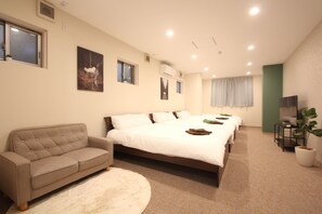 A bedroom with a large bed, a sofa, a TV, and a plant. - Perfect Koenji Location / Quiet Street, Close to All (杉並区高円寺南４丁目４−１２)