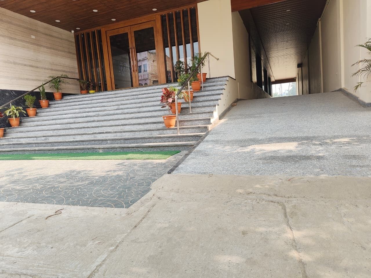 A staircase leading to a building entrance with potted plants on the steps.