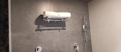 Un baño con toallero, ducha e inodoro.