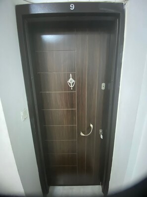 A dark wooden door with a numeric keypad lock, a keyhole, and a handle. - SOYDAN WORLD TRAVEL APART HOTEL (Antalya)