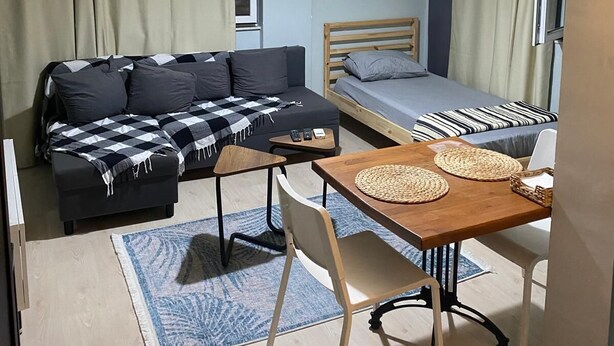 A compact bedroom with a bed, a sofa, a small table, and a chair. - SOYDAN WORLD TRAVEL APART HOTEL (Antalya)