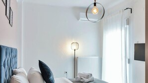 Een moderne slaapkamer met een zwevend bed, een nachtkastje met een lamp en uitzicht op de omgeving.