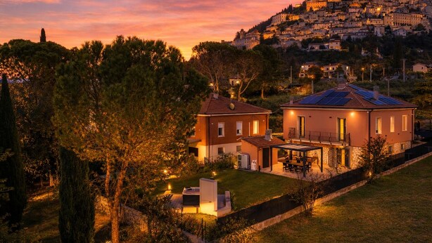 Zona residencial con una casa que tiene un patio, piscina y paneles solares.