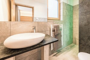 A bathroom with a white sink, a mirror, and a towel rack. - XL - Apartments Sand in Taufers 0L (Sand in Taufers)