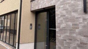 Un edificio moderno con facciata beige, ampie vetrate e una sezione con decorazione a mattoni.