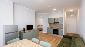 A modern apartment with a kitchen, dining area, and living room. - Sea View Apartment (Margherita di Savoia)